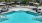 a pool with lounge chairs and umbrellas by it