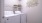 a white laundry room with a basket on top of a white washing machine