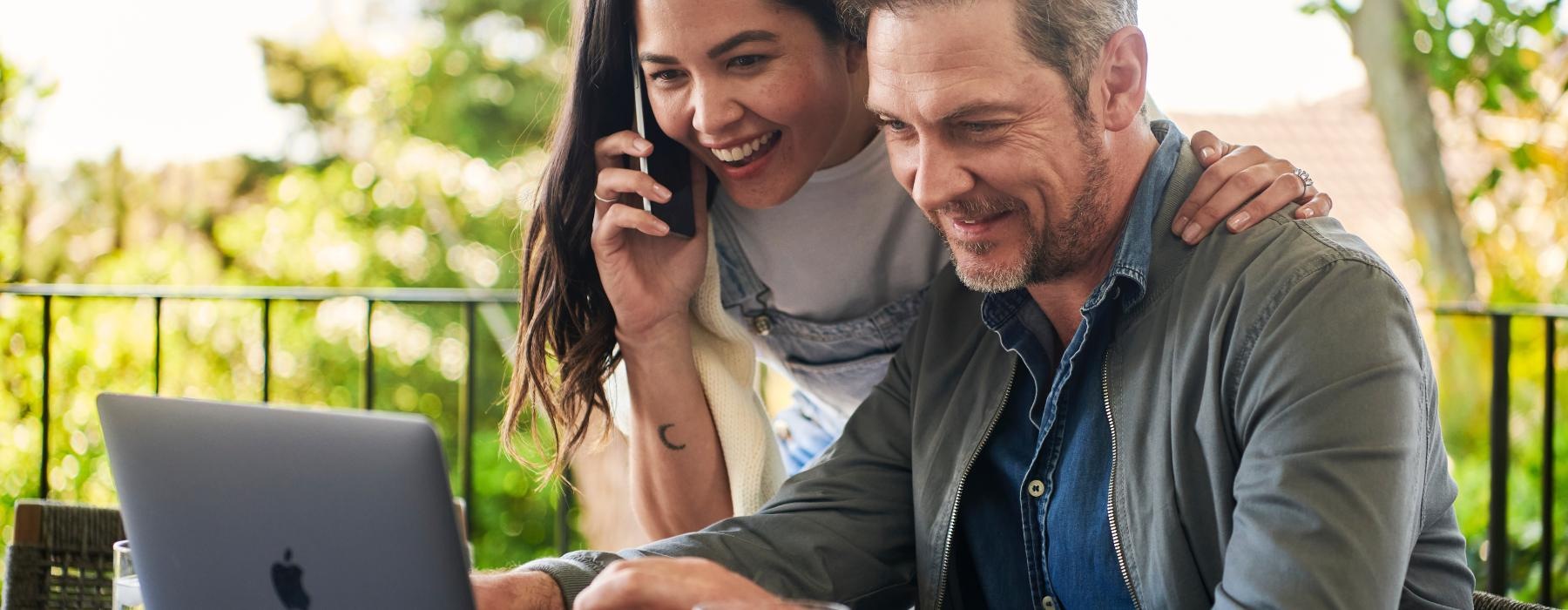 a man and a woman looking at a laptop