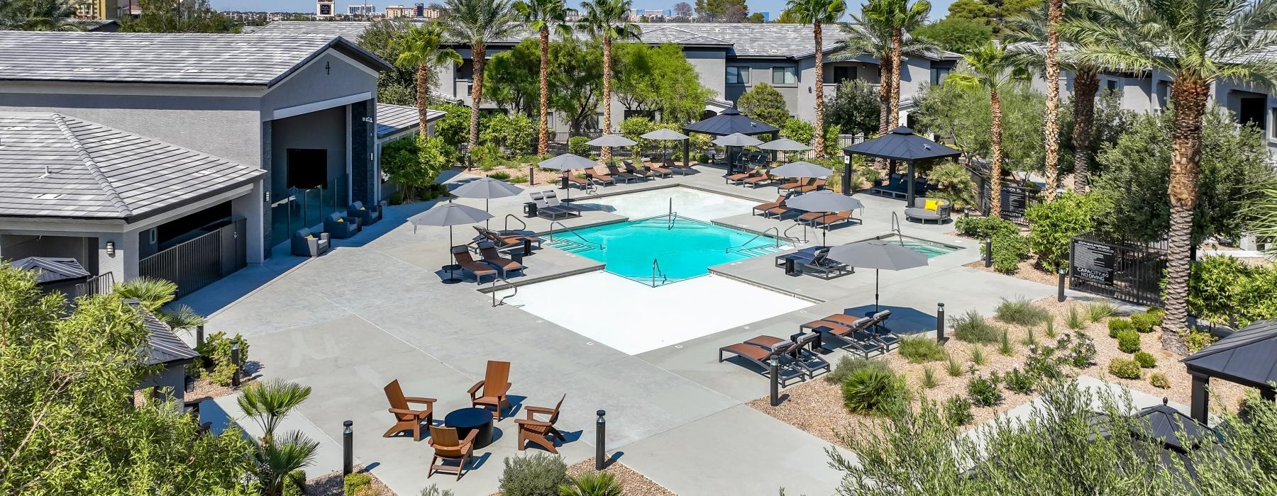 a pool and lounge chairs in a backyard